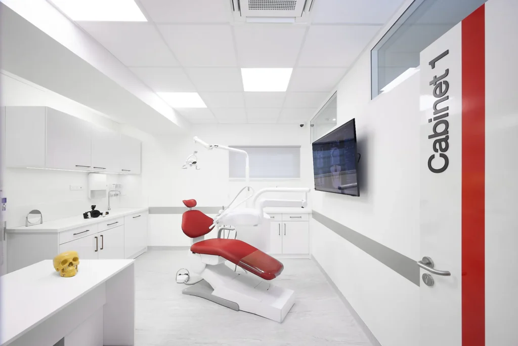 Salle de soins « Cabinet 1 » du cabinet de chirurgie maxillo-faciale, d'implantologie et de stomatologie du Dr Nader Baccar à Saran, porte blanche à bande rouge