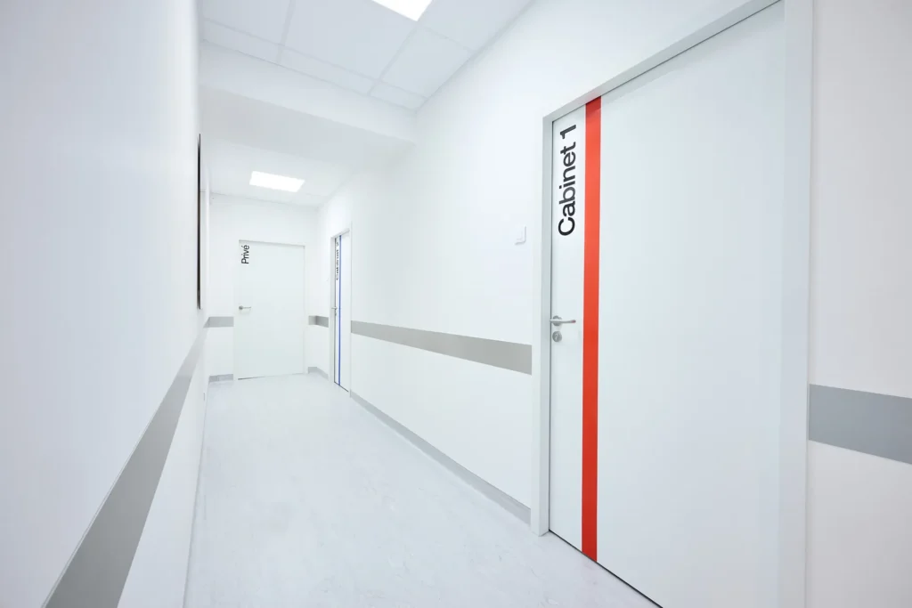 Couloir du cabinet de chirurgie maxillo-faciale, d'implantologie et de stomatologie et porte du Cabinet 1