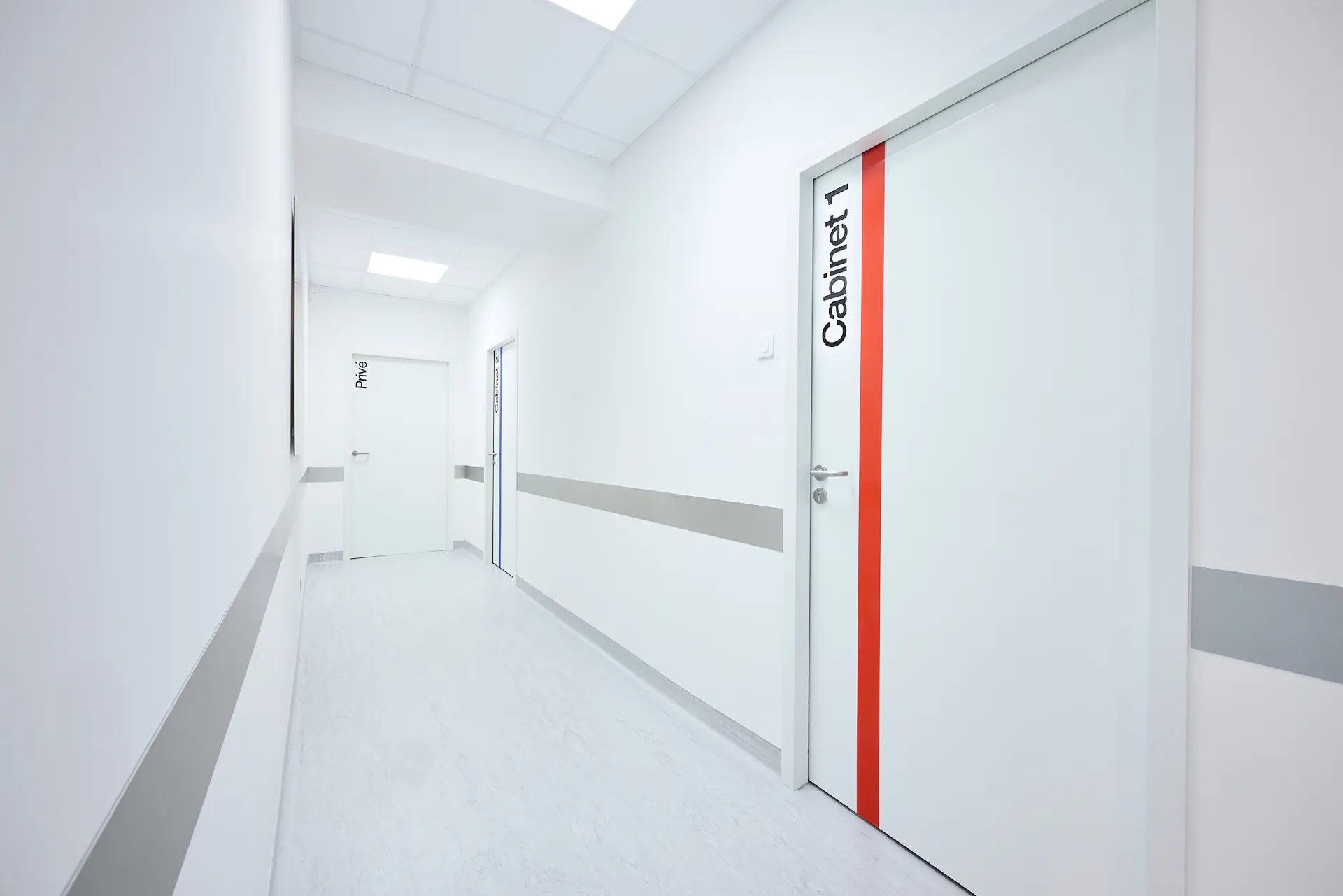 Couloir du cabinet de chirurgie maxillo-faciale, d'implantologie et de stomatologie et porte du Cabinet 1
